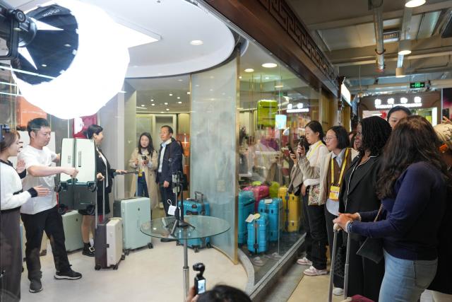 (251014) -- BEIJING, Oct. 14, 2025 (Xinhua) -- Representatives, who are in Beijing for the Global Leaders' Meeting on Women, watch a demonstration of live-streaming e-commerce while visiting the Silk Street building in Beijing, capital of China, Oct. 14, 2025. (Xinhua/Xu Bingjie)