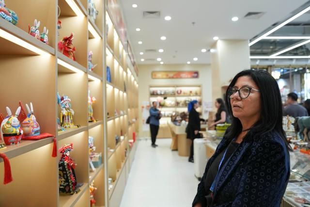 (251014) -- BEIJING, Oct. 14, 2025 (Xinhua) -- A representative, who is in Beijing for the Global Leaders' Meeting on Women, learns about Beijing clay sculptures while visiting the Silk Street building in Beijing, capital of China, Oct. 14, 2025. (Xinhua/Xu Bingjie)