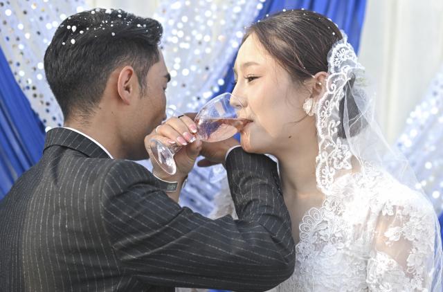 (251014) -- TEKES, Oct. 14, 2025 (Xinhua) -- The newlyweds Kumusi Yesdawulti and Bukehan Yelszi have wine during an outdoor wedding at a forest park in Tekes County, northwest China's Xinjiang Uygur Autonomous Region, Oct. 11, 2025.
  A blue sky, white clouds, vast grassland, horses and automobiles set a poetic and picturesque wedding scene for the newlyweds Kumusi Yesdawulti and Bukehan Yelszi. 
  For the couple, having fallen in love a year ago, a traditional wedding ceremony was at the top of their to-do list.
  Without a hair out of place, Kumusi, dressed head to toe in traditional costume and adorned in a red veil, married her better half Bukehan, describing the wedding as a dream realized.
  Throughout the wedding festivities, the couple's loved ones congregated to join in the celebration. Some of them played traditional musical instruments, such as dombra, and performed inspiring festive dances, while others lent their hands to prepare local specialties, including naan bread and baursak.
  A modern outdoor wedding ensued at dusk in a forest park, where the couple shared champagne and danced with their relatives and friends. The event's long-lasting atmosphere of joy, harmony and warmth drew locals and tourists to immerse themselves in joy and happiness together.
  "With horses and automobiles, the wedding is really special and lively," said Kumusi. (Xinhua/Hu Huhu)