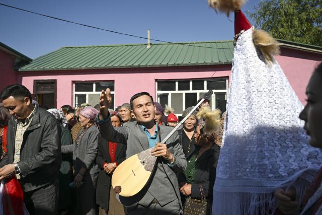 (251014) -- TEKES, Oct. 14, 2025 (Xinhua) -- A villager plays the ethnic musical instrument dombra beside the bride Kumusi Yesdawulti in Karadala Township of Tekes County, northwest China's Xinjiang Uygur Autonomous Region, Oct. 11, 2025.
  A blue sky, white clouds, vast grassland, horses and automobiles set a poetic and picturesque wedding scene for the newlyweds Kumusi Yesdawulti and Bukehan Yelszi. 
  For the couple, having fallen in love a year ago, a traditional wedding ceremony was at the top of their to-do list.
  Without a hair out of place, Kumusi, dressed head to toe in traditional costume and adorned in a red veil, married her better half Bukehan, describing the wedding as a dream realized.
  Throughout the wedding festivities, the couple's loved ones congregated to join in the celebration. Some of them played traditional musical instruments, such as dombra, and performed inspiring festive dances, while others lent their hands to prepare local specialties, including naan bread and baursak.
  A modern outdoor wedding ensued at dusk in a forest park, where the couple shared champagne and danced with their relatives and friends. The event's long-lasting atmosphere of joy, harmony and warmth drew locals and tourists to immerse themselves in joy and happiness together.
  "With horses and automobiles, the wedding is really special and lively," said Kumusi. (Xinhua/Hu Huhu)