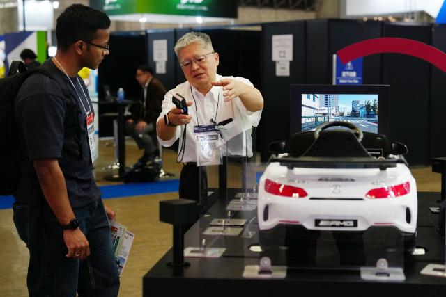 (251014) -- CHIBA, Oct. 14, 2025 (Xinhua) -- A staff member introduces intelligent driving technologies to a participant at the Combined Exhibition of Advanced Technologies (CEATEC) 2025 in Chiba Prefecture, Japan, on Oct. 14, 2025. The CEATEC 2025 kicked off here on Tuesday. (Xinhua/Jia Haocheng)