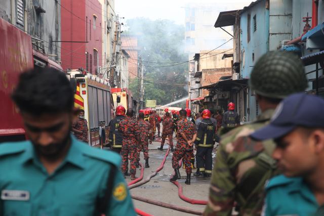 (251014) -- DHAKA, Oct. 14, 2025 (Xinhua) -- Photo taken on Oct. 14, 2025 shows firefighters working to put out the fire at a garment factory and a chemical warehouse in Dhaka, Bangladesh. At least 16 people were killed after a devastating fire tore through a garment factory and a chemical warehouse in the Bangladeshi capital of Dhaka. (Photo by Habibur Rahman/Xinhua)