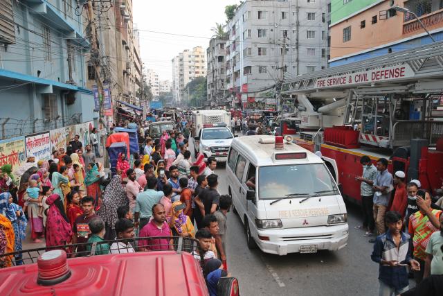 (251014) -- DHAKA, Oct. 14, 2025 (Xinhua) -- This photo taken on Oct. 14, 2025 shows ambulances arriving at the scene after fire broke out at a garment factory and a chemical warehouse in Dhaka, Bangladesh. At least 16 people were killed after a devastating fire tore through a garment factory and a chemical warehouse in the Bangladeshi capital of Dhaka. (Photo by Habibur Rahman/Xinhua)