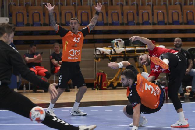 (251015) -- LJUBLJANA, Oct. 15, 2025 (Xinhua) -- Bruno Vili Zobec (1st R) of RD LL Slovan shoots and scores during the EHF Champions League Men 2025/26 match between RD LL Slovan and CS Minau Baia Mare in Ljubljana, Slovenia, Oct. 14, 2025. (Photo by Zeljko Stevanic/Xinhua)