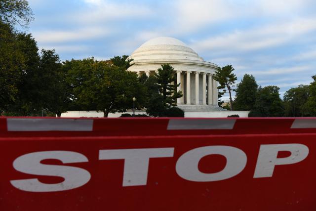 (251015) -- WASHINGTON, Oct. 15, 2025 (Xinhua) -- A stop sign is seen in front of the Thomas Jefferson Memorial in Washington, D.C., the United States, on Oct. 14, 2025. As the U.S. federal government shutdown stretches into its third week, Treasury Secretary Scott Bessent warned that the closure is already beginning to weigh on the real economy. (Xinhua/Li Rui)