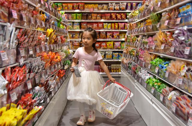 (251015) -- BEIJING, Oct. 15, 2025 (Xinhua) -- A girl selects snacks at a store in Mengzi City, southwest China's Yunnan Province, Oct. 15, 2025.
  China's consumer prices showed further signs of stabilization in September, as core inflation reached its highest level in 19 months, underscoring a gradual strengthening in domestic demand.
  The headline CPI also showed a positive trend -- logging a 0.1 percent month-on-month increase from a flat August and narrowing its year-on-year decline to 0.3 percent, compared with a 0.4 percent drop in August. (Photo by Xue Yingying/Xinhua)