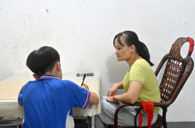 (251015) -- FENGSHAN, Oct. 15, 2025 (Xinhua) -- Lan Yezhen (R) helps her younger son with his homework at her home in Fengshan County, south China's Guangxi Zhuang Autonomous Region, Oct. 13, 2025.
  Lan Yezhen, a visually impaired writer from rural Guangxi, has carved a path of resilience through words.
   Life took a harsh turn when she had to forgo the national college entrance examination after her mother's passing. She then spent years working as a migrant worker.
   In 2018, progressive eye conditions left her completely blind, plunging the mother of two young children into despair.
   Amid the darkness, audiobooks became her beacon of solace. Inspired by literary characters who overcame adversity, she began documenting her own life story.
   With growing support from her community and beyond, Lan persisted in her writing. Her essays were published in literary journals, which led to her admission into the Guangxi Writers Association in 2024.
   Through her words, she invites readers into her inner world and reveals the hope that endures despite adversity.
   "Writing helped me find my own light," Lan said. "Even in darkness, I can carve out a path forward for myself." (Xinhua/Lu Boan)