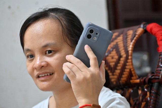 (251015) -- FENGSHAN, Oct. 15, 2025 (Xinhua) -- Lan Yezhen listens to an audiobook on her phone at her home in Fengshan County, south China's Guangxi Zhuang Autonomous Region, Oct. 14, 2025.
  Lan Yezhen, a visually impaired writer from rural Guangxi, has carved a path of resilience through words.
   Life took a harsh turn when she had to forgo the national college entrance examination after her mother's passing. She then spent years working as a migrant worker.
   In 2018, progressive eye conditions left her completely blind, plunging the mother of two young children into despair.
   Amid the darkness, audiobooks became her beacon of solace. Inspired by literary characters who overcame adversity, she began documenting her own life story.
   With growing support from her community and beyond, Lan persisted in her writing. Her essays were published in literary journals, which led to her admission into the Guangxi Writers Association in 2024.
   Through her words, she invites readers into her inner world and reveals the hope that endures despite adversity.
   "Writing helped me find my own light," Lan said. "Even in darkness, I can carve out a path forward for myself." (Xinhua/Lu Boan)