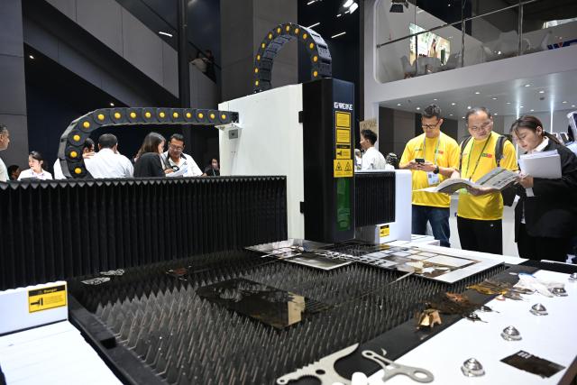 (251015) -- GUANGZHOU, Oct. 15, 2025 (Xinhua) -- Buyers visit a booth exhibiting laser cutting machines during the 138th edition of the China Import and Export Fair in Guangzhou, south China's Guangdong Province, Oct. 15, 2025. The 138th edition of the China Import and Export Fair, also known as the Canton Fair, kicked off in Guangzhou on Wednesday, with the number of booths reaching 74,600 and exhibitors exceeding 32,000, both record high figures in the history of this famous event. (Xinhua/Deng Hua)