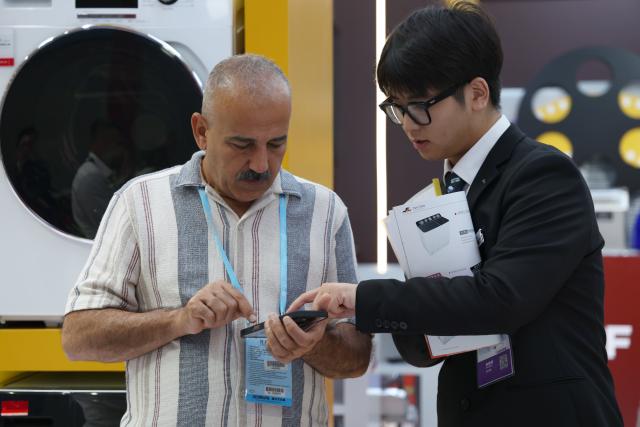 (251015) -- GUANGZHOU, Oct. 15, 2025 (Xinhua) -- A buyer (L) communicates with an exhibitor during the 138th edition of the China Import and Export Fair in Guangzhou, south China's Guangdong Province, Oct. 15, 2025. The 138th edition of the China Import and Export Fair, also known as the Canton Fair, kicked off in Guangzhou on Wednesday, with the number of booths reaching 74,600 and exhibitors exceeding 32,000, both record high figures in the history of this famous event. (Xinhua/Lu Hanxin)