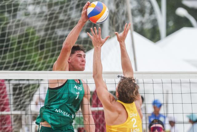 (251015) -- LAGUNA PROVINCE, Oct. 15, 2025 (Xinhua) -- Ben Hood (L) of Australia spikes the ball against Martin Licht of Canada during the men's qualification match between Ben Hood/Oliver Merritt of Australia and Luke de Greef/Martin Licht of Canada at the Volleyball World Beach Pro Tour in Laguna Province, the Philippines, Oct. 15, 2025. (Xinhua/Rouelle Umali)