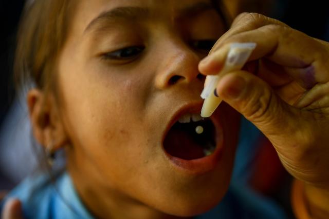 (251015) -- PARSA, Oct. 15, 2025 (Xinhua) -- A doctor administers an oral cholera vaccine to a student during the cholera vaccination campaign in Parsa district, Nepal, Oct. 15, 2025. (Photo by Sulav Shrestha/Xinhua)