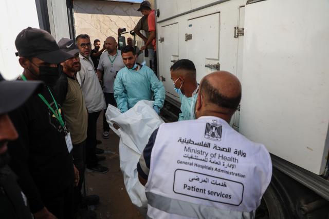 (251015) -- GAZA, Oct. 15, 2025 (Xinhua) -- Medics are seen during the examination of the bodies of Palestinians handed over from Israel to the International Committee of the Red Cross (ICRC), at Nasser Hospital in the southern Gaza Strip city of Khan Younis, Oct. 15, 2025. (Photo by Rizek Abdeljawad/Xinhua)