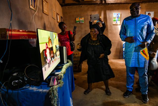 (251015) -- YAOUNDE, Oct. 15, 2025 (Xinhua) -- Villagers watch television at their home in Songmimbias, the Central Region of Cameroon on Oct. 8, 2025, after the official inauguration of the "Rural Solar" project built by a Chinese company. TO GO WITH "Zoom Africa: Solar panels light up African future" (Photo by Kepseu/Xinhua)