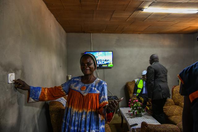 (251015) -- YAOUNDE, Oct. 15, 2025 (Xinhua) -- A woman turns on a light for the first time at her home in Nkelassi, the Central Region of Cameroon, on Oct. 8, 2025, after the official inauguration of the "Rural Solar" project built by a Chinese company. TO GO WITH "Zoom Africa: Solar panels light up African future" (Photo by Kepseu/Xinhua)