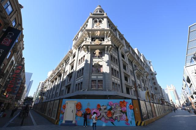 (251016) -- BEIJING, Oct. 16, 2025 (Xinhua) -- People take photos outside the hoarding of the Tianjin Quanye Bazaar in Tianjin, north China, Oct. 14, 2025.
  Quanye Bazaar, built in 1928, is a landmark shopping mall in Tianjin and a major historical and cultural site protected at the national level. 
   The renovation project of Tianjin Quanye Bazaar started in October of 2024, and the exterior part has been finished recently. The whole project is expected to be finished before Dec. 31. (Xinhua/Zhao Zishuo)