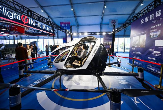 (251016) -- TIANJIN, Oct. 16, 2025 (Xinhua) -- People learn about an electric vertical takeoff and landing (eVTOL) aircraft during the 7th China Helicopter Exposition in Tianjin, north China, Oct. 16, 2025. Spanning an exhibition area of approximately 160,000 square meters, the exposition kicked off here on Thursday and will last until Oct. 19. (Xinhua/Zhao Zishuo)