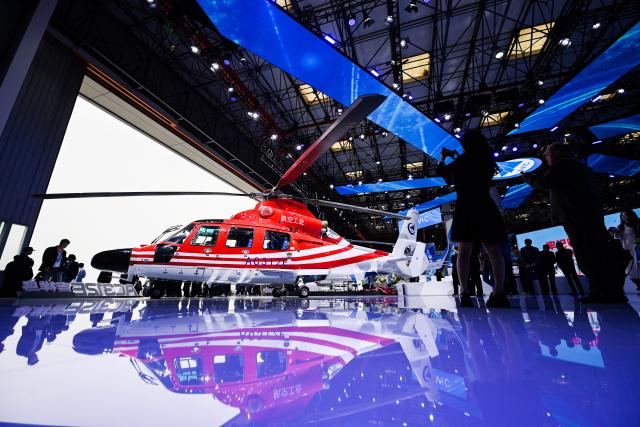 (251016) -- TIANJIN, Oct. 16, 2025 (Xinhua) -- People view an AC312E helicopter during the 7th China Helicopter Exposition in Tianjin, north China, Oct. 16, 2025. Spanning an exhibition area of approximately 160,000 square meters, the exposition kicked off here on Thursday and will last until Oct. 19. (Xinhua/Zhao Zishuo)