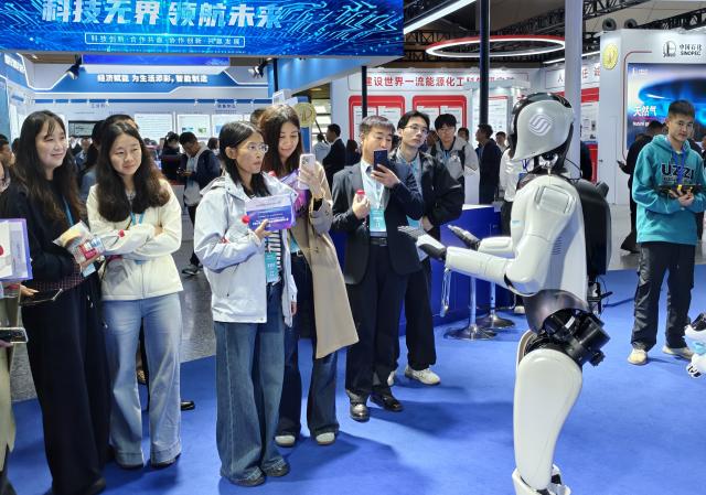 (251016) -- DALIAN, Oct. 16, 2025 (Xinhua) -- People look at a humanoid robot of China Mobile at the 14th China International Patent Fair in Dalian, northeast China's Liaoning Province, Oct. 13, 2025. TO GO WITH "China Focus: Chinese award-winning patents fuel world's green, healthy future" (Photo by Zhao Junxiang/Xinhua)
