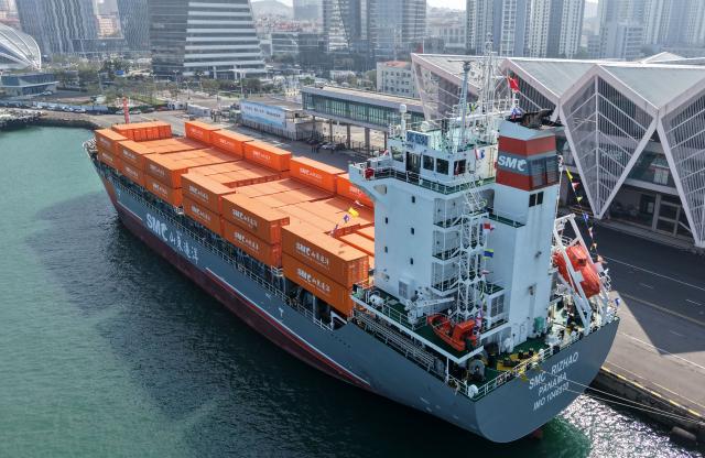 (251016) -- QINGDAO, Oct. 16, 2025 (Xinhua) -- A drone photo taken on Oct. 16, 2025 shows the "SMC RIZHAO" ship performing the maiden voyage of the Qingdao-Jeju container shipping route berthing at the Qingdao International Cruise Terminal in Qingdao, east China's Shandong Province. A regular direct container shipping route between Qingdao and South Korea's Jeju was launched on Thursday. This express shipping route will operate once a week in its initial stage, significantly enhancing the logistics efficiency between the two places, effectively reducing logistics costs, and further densifying the shipping network of east China's Shandong Province to South Korea. (Xinhua/Li Ziheng)