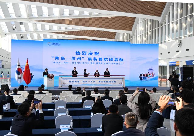 (251016) -- QINGDAO, Oct. 16, 2025 (Xinhua) -- A launch ceremony of the Qingdao-Jeju container shipping route is held at the Qingdao International Cruise Terminal in Qingdao, east China's Shandong Province, on Oct. 16, 2025. A regular direct container shipping route between Qingdao and South Korea's Jeju was launched on Thursday. This express shipping route will operate once a week in its initial stage, significantly enhancing the logistics efficiency between the two places, effectively reducing logistics costs, and further densifying the shipping network of east China's Shandong Province to South Korea. (Xinhua/Li Ziheng)