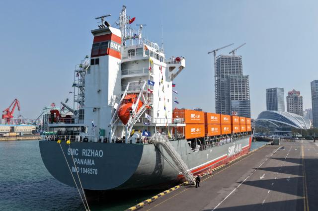 (251016) -- QINGDAO, Oct. 16, 2025 (Xinhua) -- A drone photo taken on Oct. 16, 2025 shows the "SMC RIZHAO" ship performing the maiden voyage of the Qingdao-Jeju container shipping route berthing at the Qingdao International Cruise Terminal in Qingdao, east China's Shandong Province. A regular direct container shipping route between Qingdao and South Korea's Jeju was launched on Thursday. This express shipping route will operate once a week in its initial stage, significantly enhancing the logistics efficiency between the two places, effectively reducing logistics costs, and further densifying the shipping network of east China's Shandong Province to South Korea. (Xinhua/Li Ziheng)