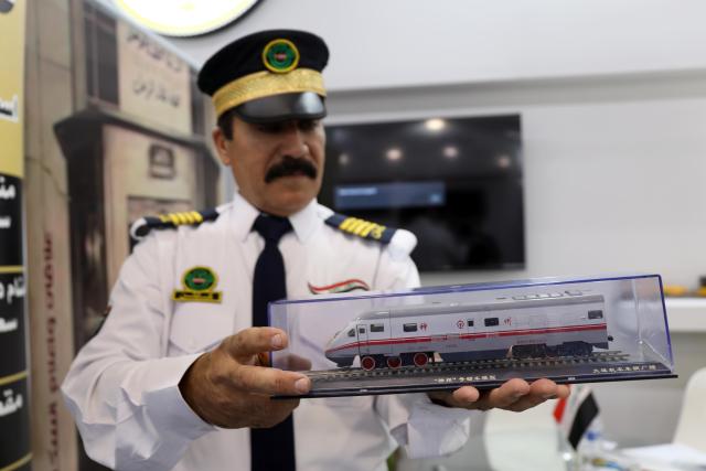 (251016) -- BAGHDAD, Oct. 16, 2025 (Xinhua) -- A man displays a train miniature during the Iraq International Transportation, Airports, and Logistics Expo, in Baghdad, Iraq, Oct. 16, 2025. The Iraq International Transportation, Airports, and Logistics Expo is held in Iraq's capital Baghdad from Oct. 15 to 18. (Xinhua/Khalil Dawood)