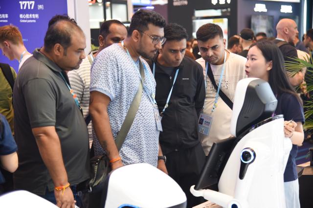 (251017) -- GUANGZHOU, Oct. 17, 2025 (Xinhua) -- International buyers learn about service robots during the 138th edition of the China Import and Export Fair, also known as the Canton Fair, in Guangzhou, south China's Guangdong Province, Oct. 16, 2025. TO GO WITH "1st LD-Writethru-Economic Watch: Innovation, smart tech take center stage at 138th Canton Fair" (Xinhua/Hong Zehua)