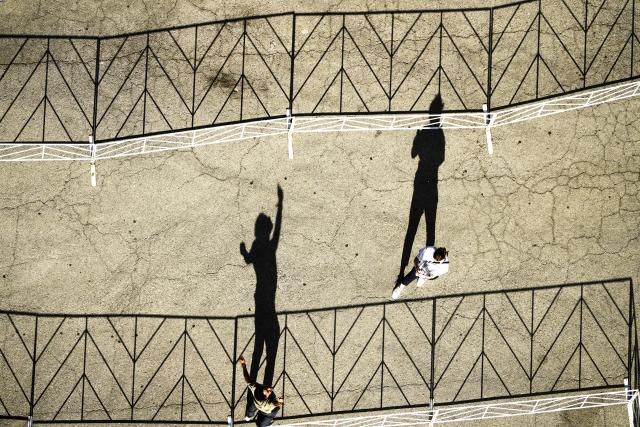 (251018) -- AUSTIN, Oct. 18, 2025 (Xinhua) -- Shadows of people are projected on the ground at sunset in Austin, Texas, the United States, Oct. 17, 2025. (Xinhua/Wu Xiaoling)
