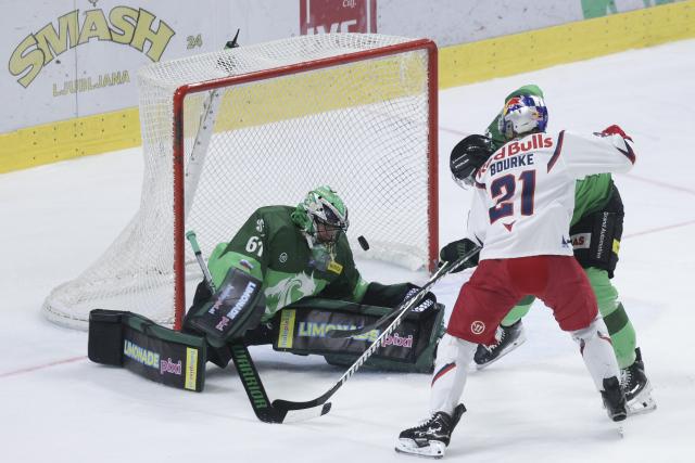 (251018) -- LJUBLJANA, Oct. 18, 2025 (Xinhua) -- Troy Bourke (front) of EC Red Bull Salzburg shoots during the 2025/26 Win2day Ice Hockey League match between HK Olimpija and EC Red Bull Salzburg in Ljubljana, Slovenia, Oct.17, 2025. (Photo by Zeljko Stevanic/Xinhua)