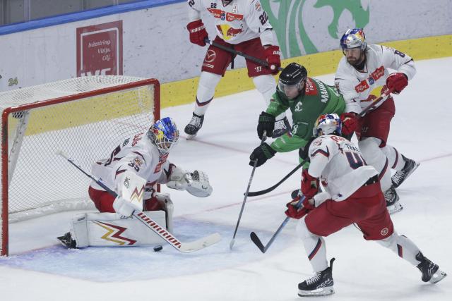 (251018) -- LJUBLJANA, Oct. 18, 2025 (Xinhua) -- Marcel Mahkovec (C) of HK Olimpija shoots during the 2025/26 Win2day Ice Hockey League match between HK Olimpija and EC Red Bull Salzburg in Ljubljana, Slovenia, Oct.17, 2025. (Photo by Zeljko Stevanic/Xinhua)