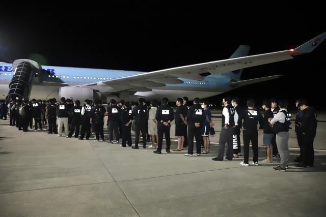 (251018) -- KANDAL, Oct. 18, 2025 (Xinhua) -- South Korean online scam suspects are escorted onto a plane at the Techo International Airport in Kandal province, Cambodia on Oct. 18, 2025. Cambodia deported 64 South Korean online scam suspects, including five women, to their birth country on Friday night, said a news release from Cambodia's Ad-Hoc Committee to Combat Online Scams on Saturday. (Agence Kampuchea Presse/Handout via Xinhua)