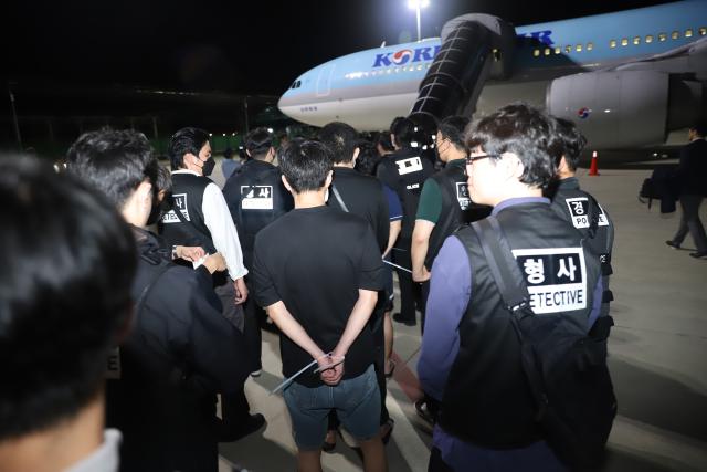 (251018) -- KANDAL, Oct. 18, 2025 (Xinhua) -- South Korean online scam suspects are escorted onto a plane at the Techo International Airport in Kandal province, Cambodia on Oct. 18, 2025. Cambodia deported 64 South Korean online scam suspects, including five women, to their birth country on Friday night, said a news release from Cambodia's Ad-Hoc Committee to Combat Online Scams on Saturday. (Agence Kampuchea Presse/Handout via Xinhua)