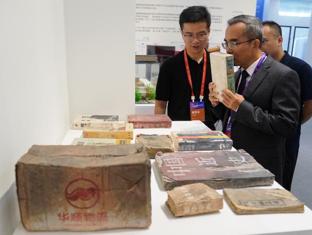 (251018) -- JINGDEZHEN, Oct. 18, 2025 (Xinhua) -- Visitors watch ceramic products shaped like paper books during the 2025 China Jingdezhen International Ceramic Expo in Jingdezhen, east China's Jiangxi Province, Oct. 18, 2025. The 2025 China Jingdezhen International Ceramic Expo opened on Saturday in Jingdezhen, an eastern Chinese city famed as the "porcelain capital," attracting more than 1,000 buyers from home and abroad. (Xinhua/Zhou Mi)