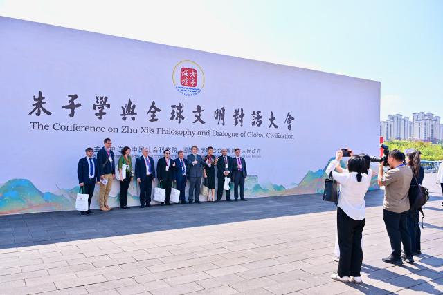 (251018) -- NANPING, Oct. 18, 2025 (Xinhua) -- Participants pose for a group photo in front of a board for the Conference on Zhu Xi's Philosophy and Dialogue of Global Civilization in Nanping City, southeast China's Fujian Province, Oct. 18, 2025. The Conference on Zhu Xi's Philosophy and Dialogue of Global Civilization was held here on Saturday.
   Zhu Xi was a great Chinese philosopher and a Confucian scholar of the Southern Song Dynasty (1127-1279). (Xinhua/Jiang Kehong)