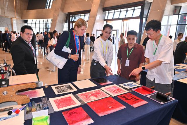 (251018) -- NANPING, Oct. 18, 2025 (Xinhua) -- Participants learn about traditional woodblock printing at the Conference on Zhu Xi's Philosophy and Dialogue of Global Civilization in Nanping City, southeast China's Fujian Province, Oct. 18, 2025. The Conference on Zhu Xi's Philosophy and Dialogue of Global Civilization was held here on Saturday.
   Zhu Xi was a great Chinese philosopher and a Confucian scholar of the Southern Song Dynasty (1127-1279). (Xinhua/Jiang Kehong)