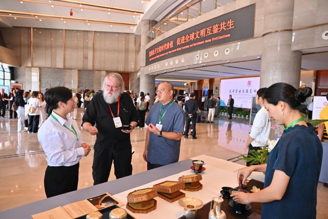 (251018) -- NANPING, Oct. 18, 2025 (Xinhua) -- Participants learn about traditional Chinese tea-making technique at the Conference on Zhu Xi's Philosophy and Dialogue of Global Civilization in Nanping City, southeast China's Fujian Province, Oct. 18, 2025. The Conference on Zhu Xi's Philosophy and Dialogue of Global Civilization was held here on Saturday.
   Zhu Xi was a great Chinese philosopher and a Confucian scholar of the Southern Song Dynasty (1127-1279). (Xinhua/Jiang Kehong)