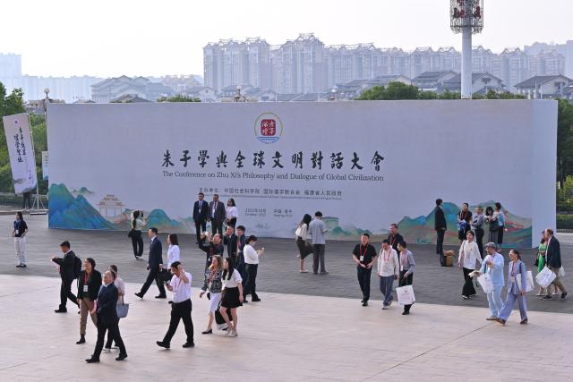 (251018) -- NANPING, Oct. 18, 2025 (Xinhua) -- Participants walk past a board for the Conference on Zhu Xi's Philosophy and Dialogue of Global Civilization in Nanping City, southeast China's Fujian Province, Oct. 18, 2025. The Conference on Zhu Xi's Philosophy and Dialogue of Global Civilization was held here on Saturday.
   Zhu Xi was a great Chinese philosopher and a Confucian scholar of the Southern Song Dynasty (1127-1279). (Xinhua/Jiang Kehong)