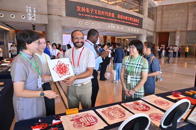 (251018) -- NANPING, Oct. 18, 2025 (Xinhua) -- Participants experience paper-cutting at the Conference on Zhu Xi's Philosophy and Dialogue of Global Civilization in Nanping City, southeast China's Fujian Province, Oct. 18, 2025. The Conference on Zhu Xi's Philosophy and Dialogue of Global Civilization was held here on Saturday.
   Zhu Xi was a great Chinese philosopher and a Confucian scholar of the Southern Song Dynasty (1127-1279). (Xinhua/Jiang Kehong)