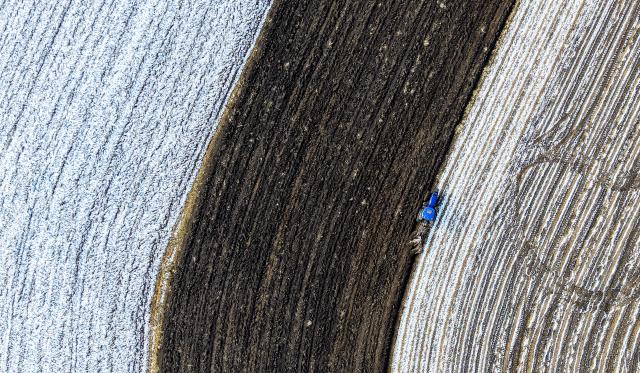 (251018) -- HARBIN, Oct. 18, 2025 (Xinhua) -- An aerial drone photo taken on Oct. 18, 2025 shows an agricultural machinery working in a snow-covered field of a farming company under Beidahuang Group in northeast China's Heilongjiang Province. As many areas in Heilongjiang Province have experienced snowfall, some agricultural production units of the Beidahuang Group have prepared the soil for winter before the ground freezes. (Photo by Huang Yongxing/Xinhua)