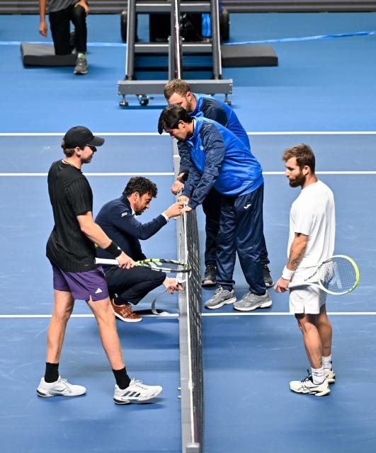 (251019) -- ALMATY, Oct. 19, 2025 (Xinhua) -- Referee checks the net during the men's singles semifinal match between Alex Michelsen (1st L) of the United States and Corentin Moutet of France at the ATP250 Almaty Tennis Open in Almaty, Kazakhstan, on Oct. 18, 2025. (Xinhua/Li Renzi)