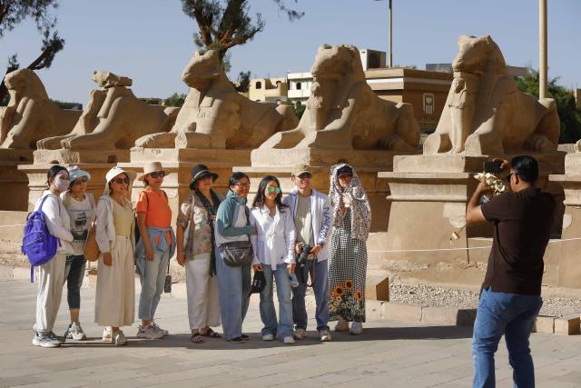 (251019) -- LUXOR, Oct. 19, 2025 (Xinhua) -- Chinese tourists pose for photos while touring the Karnak Temple Complex in Luxor, Egypt, on Oct. 5, 2025.
  TO GO WITH "Roundup: Chinese tourists help drive winter tourism revival in Egypt's Luxor " (Xinhua/Ahmed Gomaa)