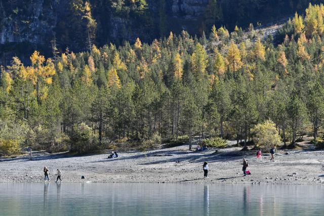 (251019) -- KANDERSTEG, Oct. 19, 2025 (Xinhua) -- People have fun along the Lake Oeschinen near Kandersteg in Bernese Oberland, Switzerland, Oct. 18, 2025.
  Lake Oeschinen, situated at an altitude of 1,578 meters near Kandersteg in Switzerland's Bernese Oberland, forms part of the UNESCO World Heritage Site "Swiss Alps Jungfrau-Aletsch." (Xinhua/Lian Yi)