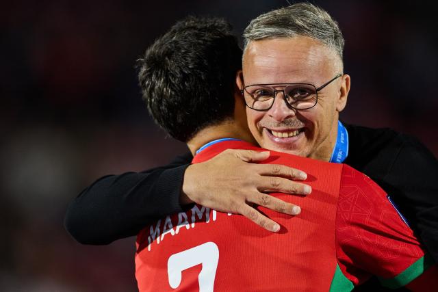 (251020) -- SANTIAGO, Oct. 20, 2025 (Xinhua) -- Mohamed Ouahbi (R), head coach of Morocco, hugs Othmane Maamma after the final match between Argentina and Morocco at the FIFA U-20 World Cup Chile 2025 in Santiago, Chile, Oct. 19, 2025. (Xinhua/Meng Dingbo)
