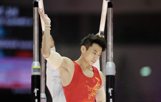 (251020) -- JAKARTA, Oct. 20, 2025 (Xinhua) -- Zou Jingyuan of China touches the parallel bars at the 53rd FIG Artistic Gymnastics World Championships in Jakarta, Indonesia, on Oct. 20, 2025. (Xinhua/Bai Xuefei)