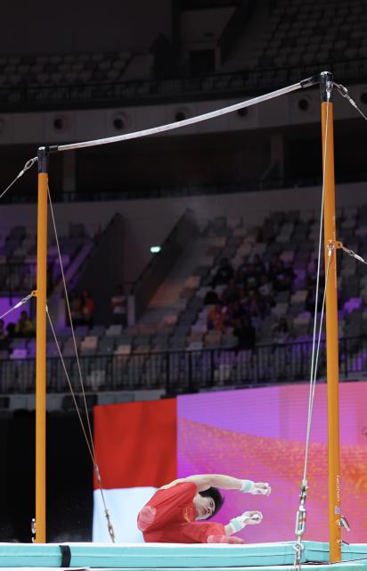 (251020) -- JAKARTA, Oct. 20, 2025 (Xinhua) -- Zhang Boheng of China falls during the Men's Horizontal Bar Qualification at the 53rd FIG Artistic Gymnastics World Championships in Jakarta, Indonesia, on Oct. 20, 2025. (Xinhua/Bai Xuefei)