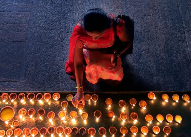 (251020) -- COLOMBO, Oct. 20, 2025 (Xinhua) -- A woman lights oil lamps to celebrate Diwali, or the Hindu festival of lights, at a temple in Colombo, Sri Lanka, on Oct. 20, 2025. (Photo by Ajith Perera/Xinhua)