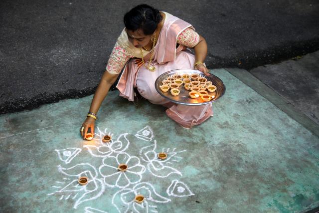 (251020) -- YANGON, Oct. 20, 2025 (Xinhua) -- A woman lights oil lamps to celebrate Diwali, or the Hindu festival of lights, in Yangon, Myanmar, Oct. 20, 2025. (Xinhua/Myo Kyaw Soe)