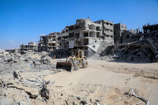 (251020) -- GAZA, Oct. 20, 2025 (Xinhua) -- A heavy machinery removes debris from a street in Gaza City, on Oct. 19, 2025. The Israel Defense Forces (IDF) said in a statement on Sunday that it had launched a new wave of strikes against Hamas militant targets in the southern Gaza Strip.
   According to the statement, the strikes were led by the IDF's Southern Command "following a ceasefire violation earlier in the day." (Photo by Rizek Abdeljawad/Xinhua)