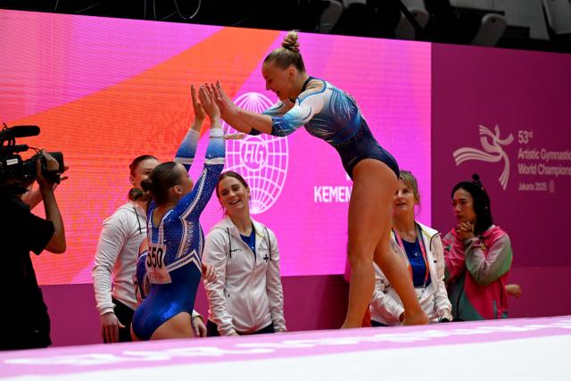 (251021) -- JAKARTA, Oct. 21, 2025 (Xinhua) -- Kaia Tanskanen (Top) of Finland greets her teammate after the Women's Floor Exercise Qualification at the 53rd FIG Artistic Gymnastics World Championships in Jakarta, Indonesia, on Oct. 20, 2025. (Xinhua/Agung Kuncahya B.)